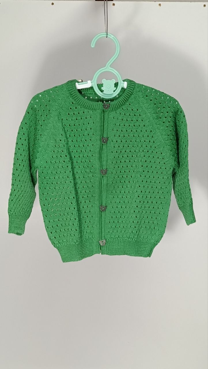 Cardigan in lana merino per bimba, lavorato con tecnica punzonata che crea un delicato effetto texture sulla superficie. La lana merino è morbida e termoregolante, ideale per proteggere dalle stagioni intermedie senza appesantire. Perfetto per i primi mesi, taglia 9-12 mesi. €30,00.