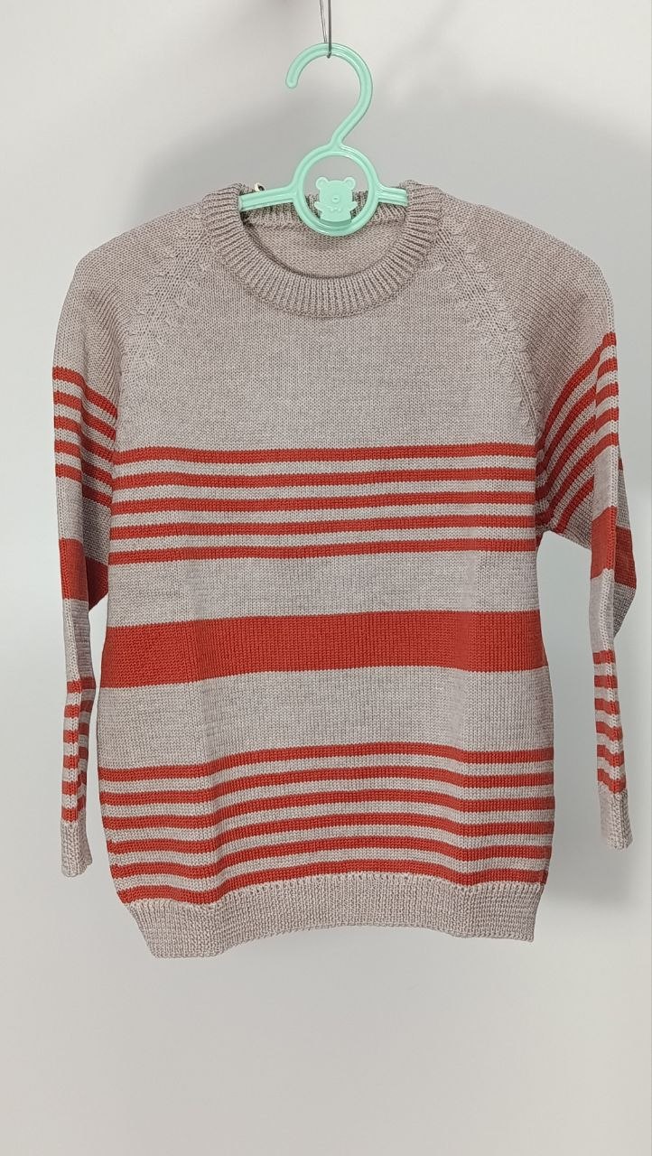 Maglioncino in lana merino con righe beige e arancione, lavorato a mano con cura nei dettagli. Un capo leggero e caldo, perfetto per le giornate di mezza stagione, che mantiene la pelle delicata del bambino protetta e confortevole. Taglia 5-6 anni. €28,00.