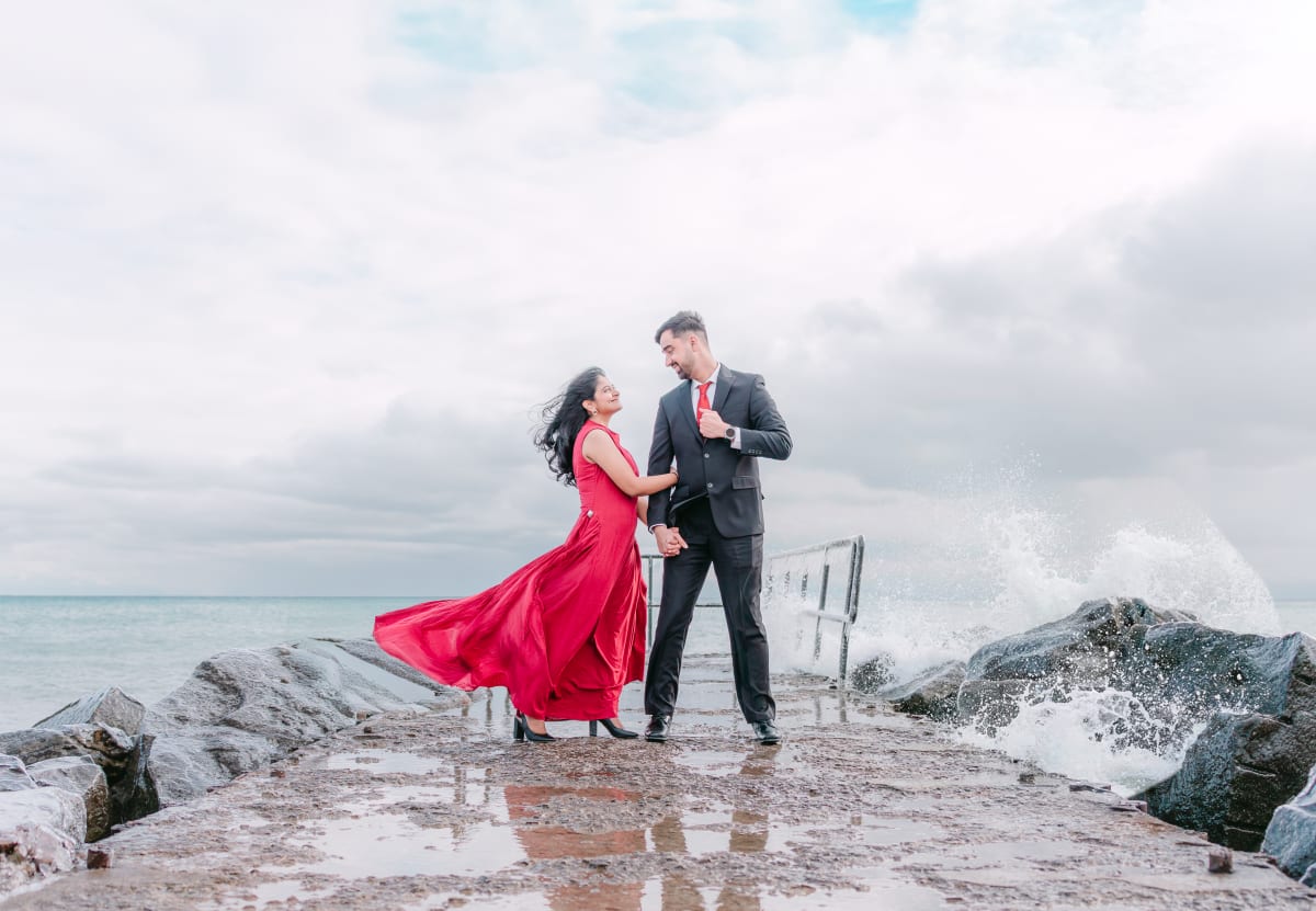 Couple in red and black on the rocks by Lake Ontario