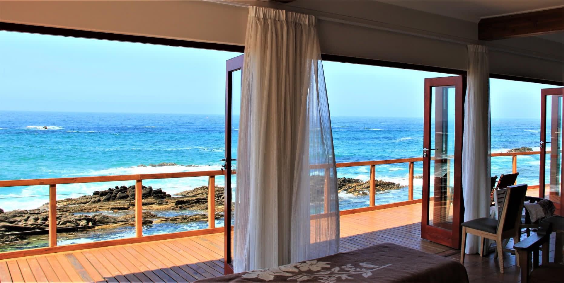 Open-plan living area at On The Rocks Villa with ocean views and stacking doors