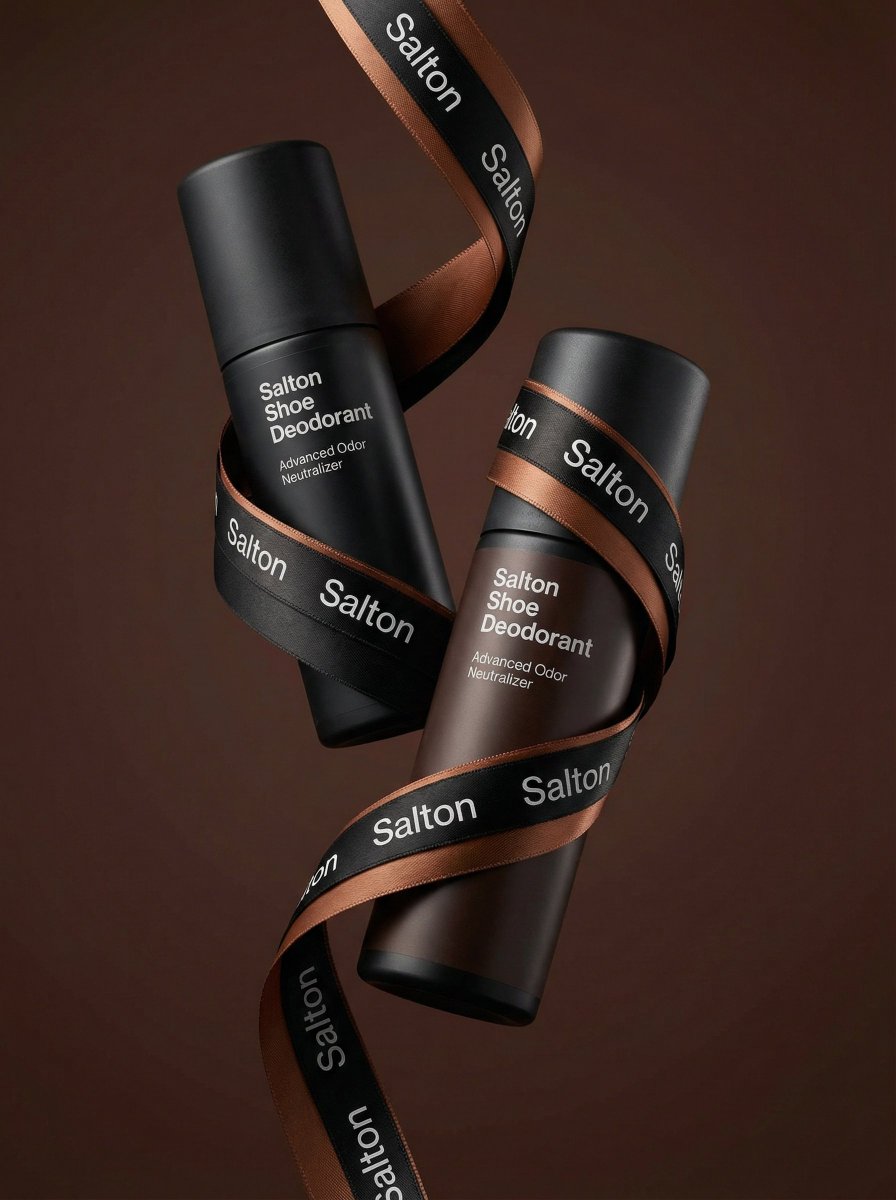 Two floating matte Salton Shoe Deodorant bottles connected by a branded satin ribbon in a warm minimalist studio background with premium lighting and diagonal composition.