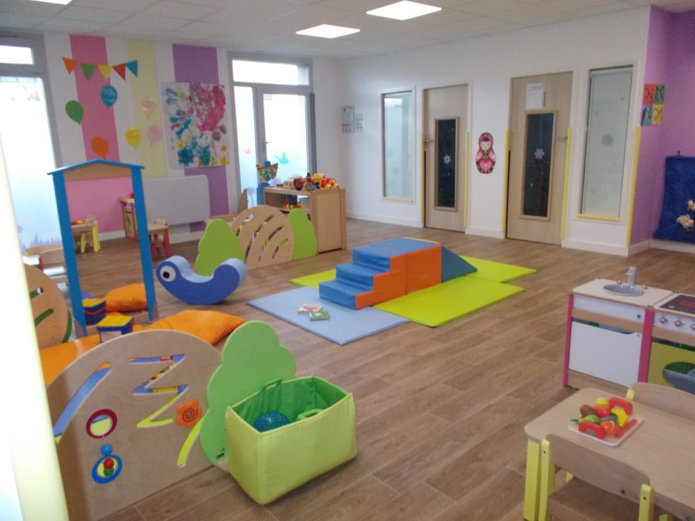 Espace de jeu lumineux et coloré à La Maison Bleue, conçu pour l'accueil de qualité des enfants.