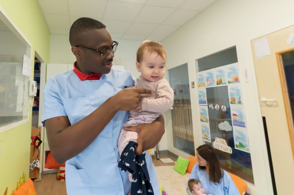 Professionnel de La Maison Bleue interagissant avec un enfant, illustrant notre engagement envers le bien-être des enfants.