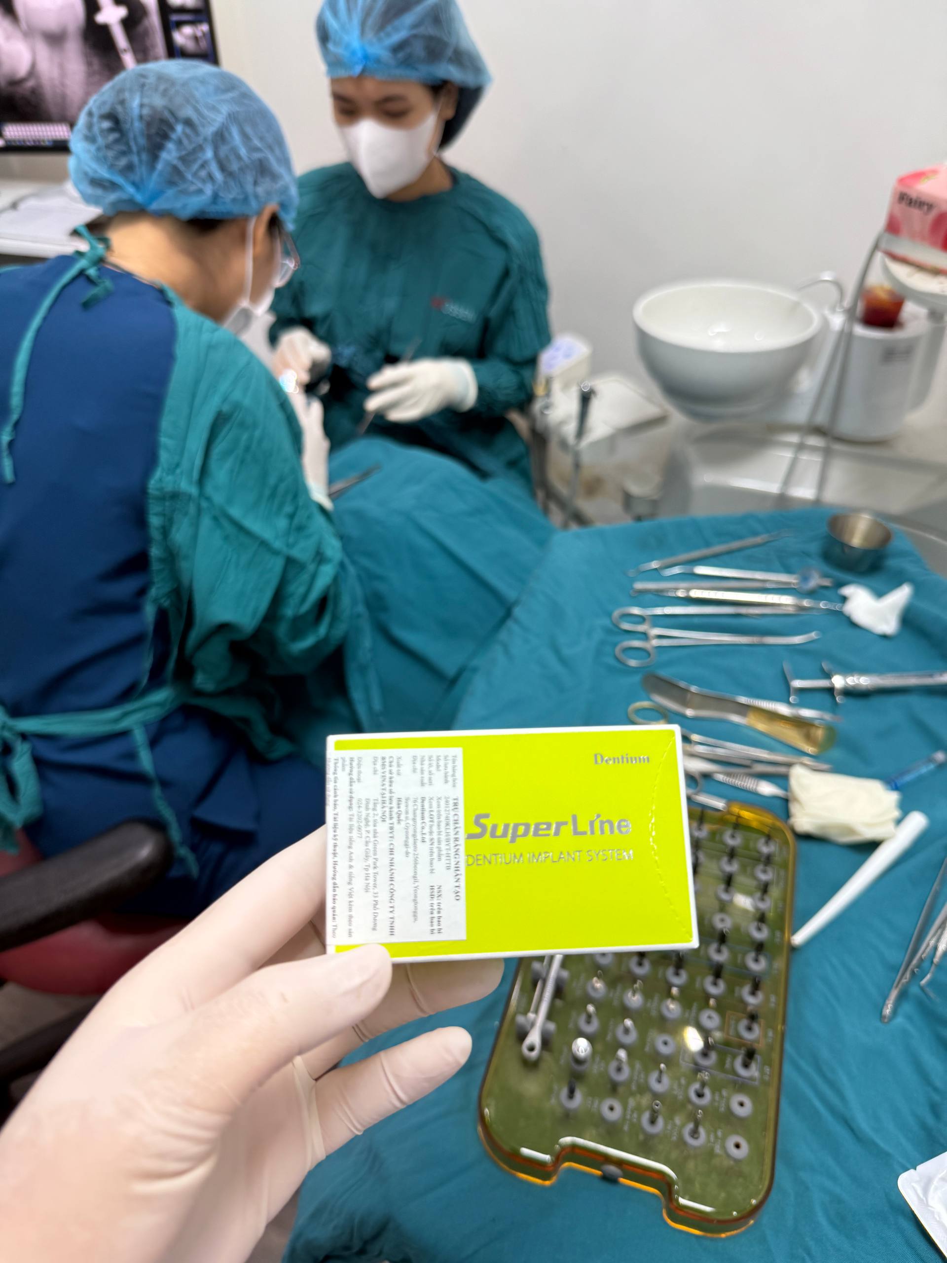 Hộp hệ thống implant Dentium SuperLine được cầm bên cạnh khu vực điều trị