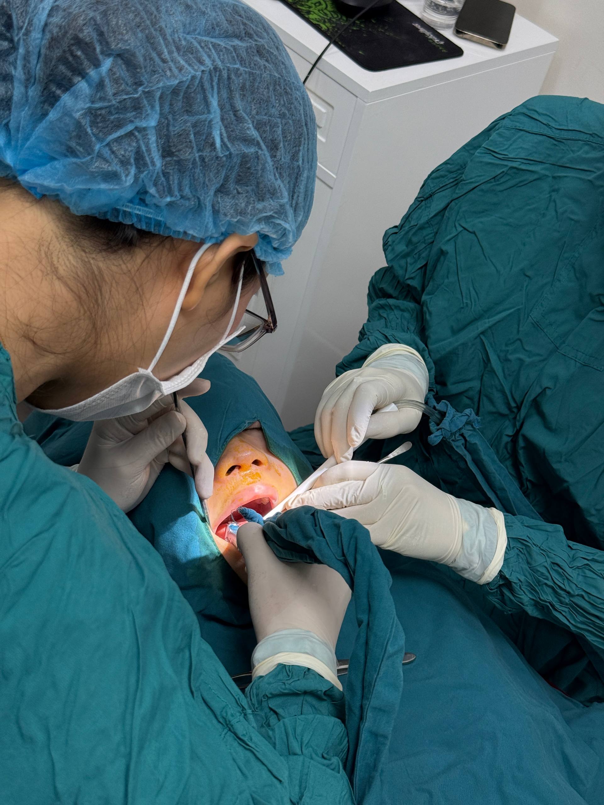 Cận cảnh đội ngũ lâm sàng thao tác trong miệng khách hàng khi điều trị implant