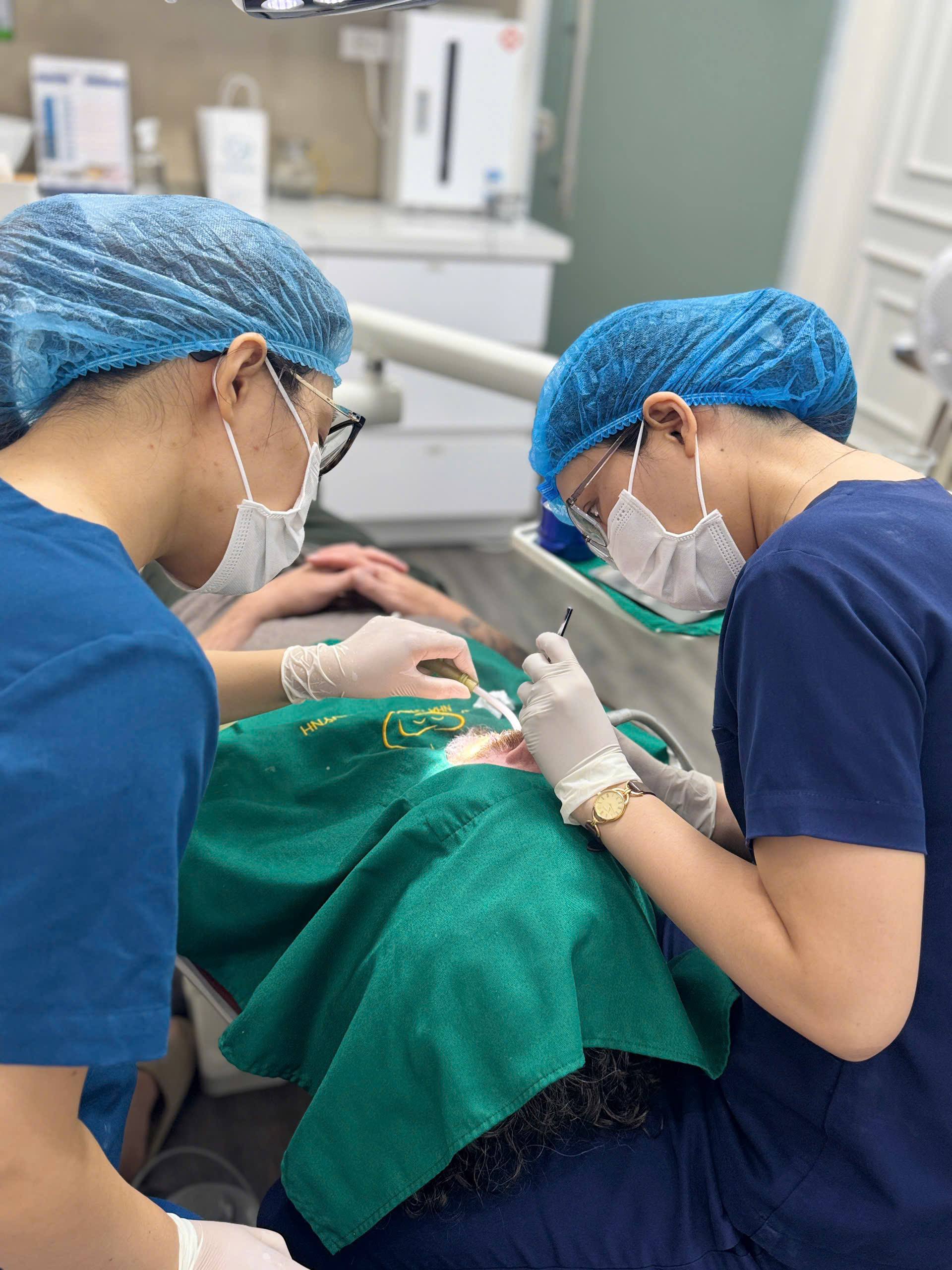 Hai nhân viên nha khoa đang điều trị cho khách hàng tại Nha Khoa Mễ Trì