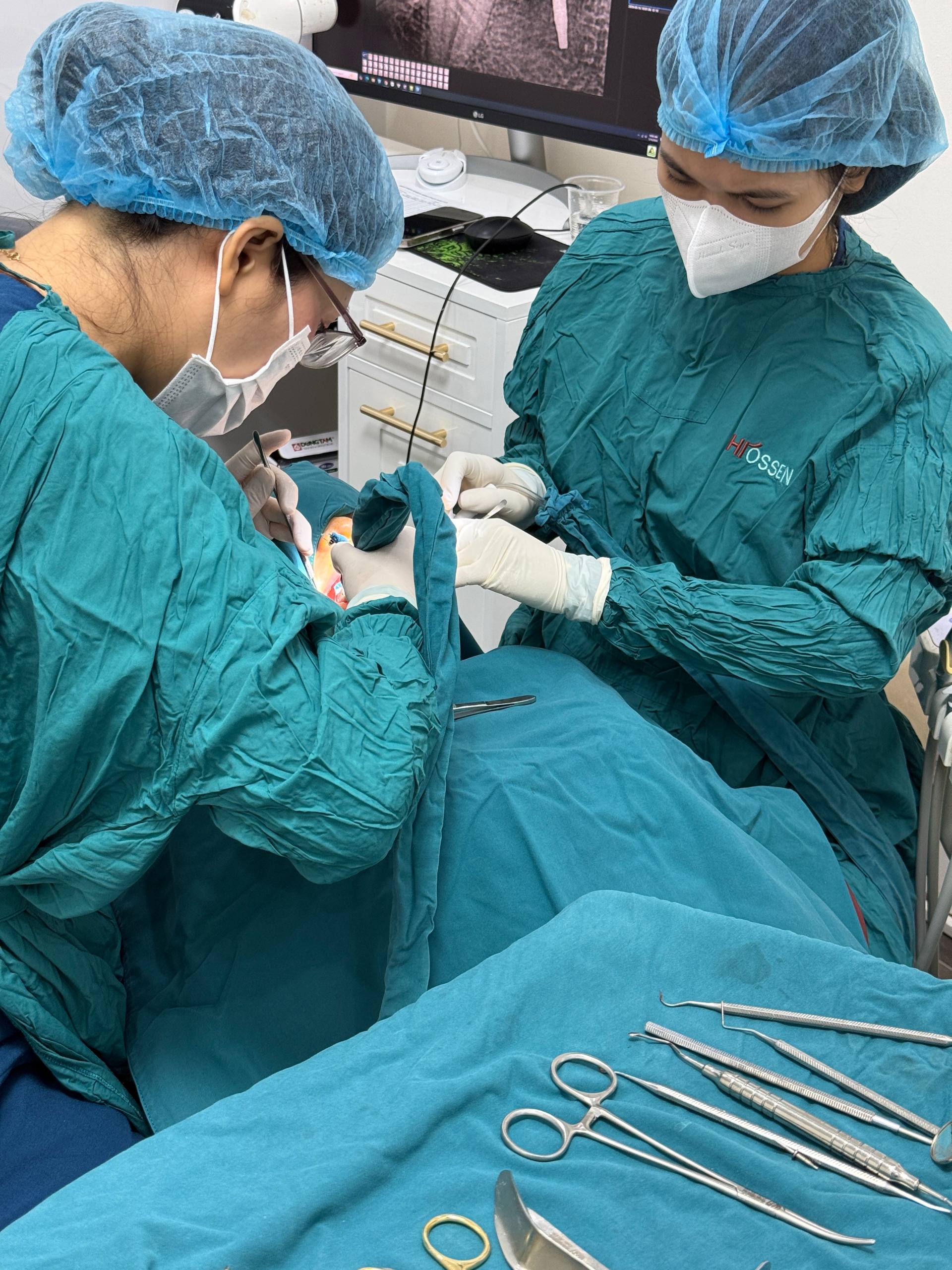 Đội ngũ lâm sàng thực hiện điều trị implant với dụng cụ phẫu thuật được chuẩn bị bên cạnh