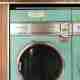 A photo of a vintage washing machine in a laundromat.
