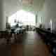 Looking towards a window inside the Vitra showroom. The room has a profile like a house with a pointed roof. Inside the room is a long table and bench.