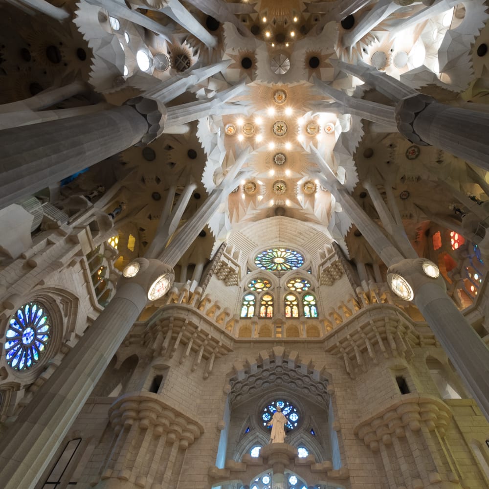 Looking towards the ceiling of the main atrium of la Sagrada Família. The very top of the ceiling is especially bright from many small lights.