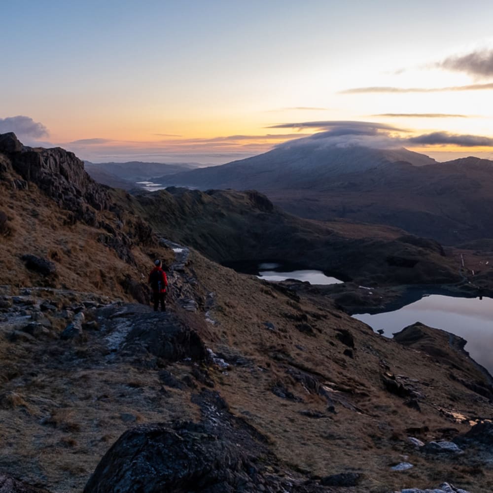 A panorama taken from midway up Snowdon before sunrise. The sky is lightening, but the landscape is still dark.