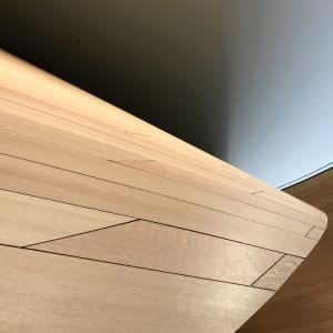 A detail of a curved wooden wall receding in to the distance.