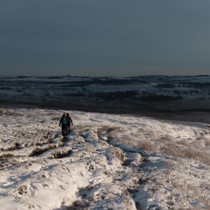 A pair of walkers decend a snow covered hill.