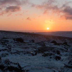 Sunrise over lightly snow covered hills.