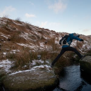 Ed Horsford mid leap whilst crossing a small stream.