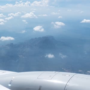 A photo of the Montserrat mountain range taken from an airplane. A plane engine is visible in the foreground.