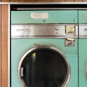 A photo of a vintage washing machine in a laundromat.