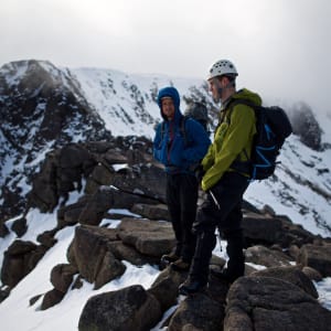 Chris and our instructor stand on a level section of Fiacaill ridge. There’s low cloud on the mountain, but some sunlight just breaking through.