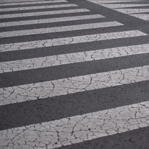 Cracked white markings on tarmac. They’re in a regular grid pattern with arrows at one end.