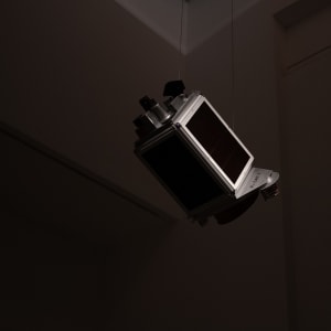 A model of a satellite is just visible in a dark gallery interior.
