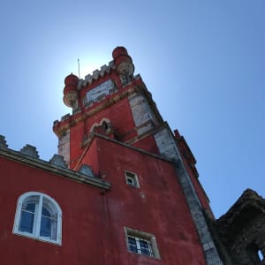 Looking up at a tall ornate red building in Pena palace.