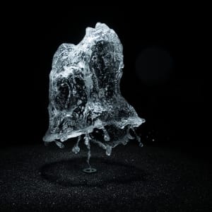 A round shower of water is frozen in mid air by strobe lighting.
