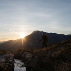 Ed walking towards the camera, approaching a small stream. It’s just after dawn and the sun is directly in front.