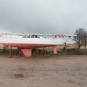 Looking side on to a small boat on stilts out of water.