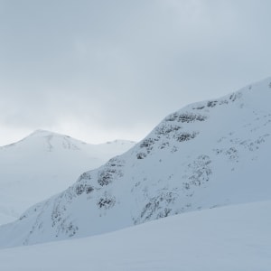 A low contrast view of several snowy ridges.