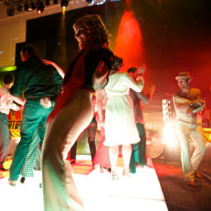 People dancing on on a lit-up dance floor.