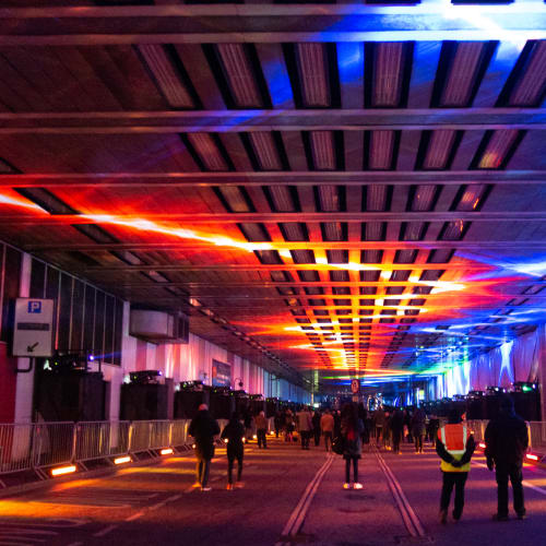 A photo looking straight down the covered Beech Street. The photo is dark, with red and blue lights on the ceiling, receding into the distance.