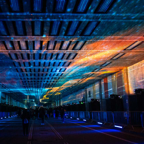 A photo looking straight down the covered Beech Street. The photo is dark, with a projection of a solar system on the ceiling.