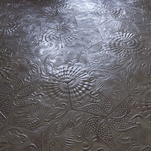 A photo of some hexagonal floor tiles in Casa Milà. There’s a rich floral texture on them.