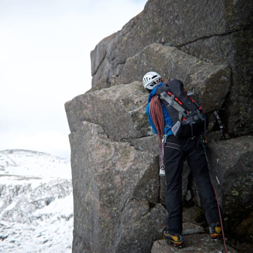 Our instructor gets placing climbing equipment on the edge of an overhang on Fiacaill ridge.