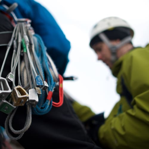 A macro photo of climbing gear on our instructor’s harness. Chris is visible in the background.