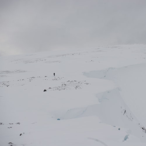 Ed in far distance is a dark spec on an otherwise white mountain.