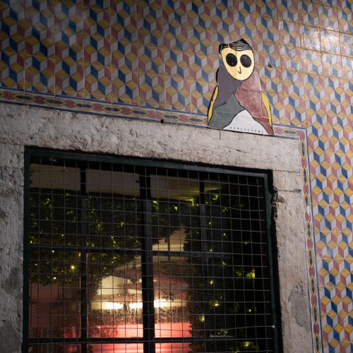 A photo of the top of an exterior window. The wall has a small decorative tile pattern and a graphic of a small person is stuck on the top right of the window.