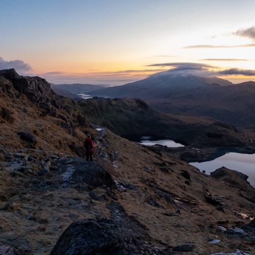 A panorama taken from midway up Snowdon before sunrise. The sky is lightening, but the landscape is still dark.