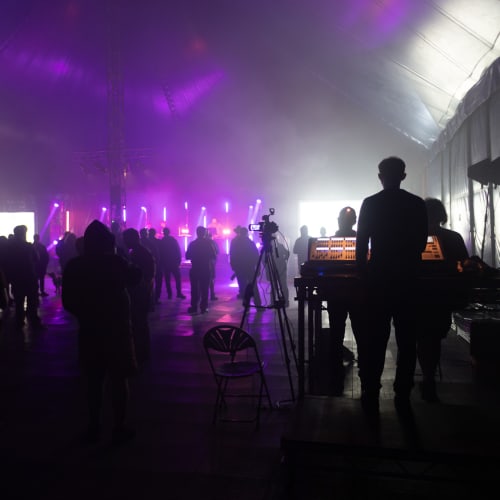 DJ booth and people dancing in a dark tent