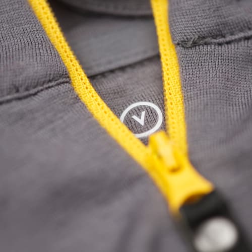 Detail photo of the zipper of a grey jersey.