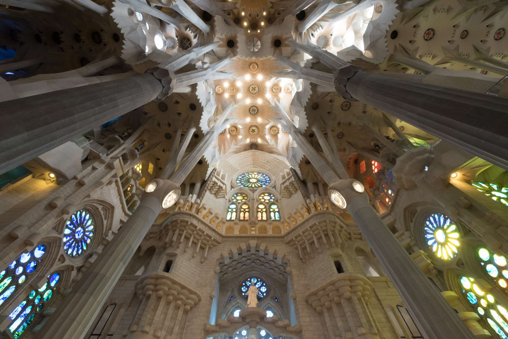 Looking towards the ceiling of the main atrium of la Sagrada Família. The very top of the ceiling is especially bright from many small lights.