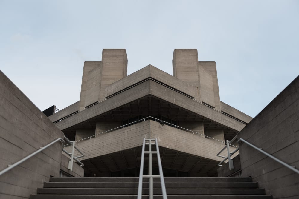 Looking up at one of the entrances to the National Theatre. The photo is symmetrical - the corner leads to a stairwell at 45º, and the camera is at the bottom of the stairs.