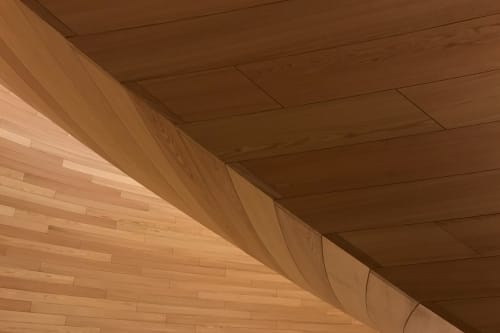A detail of a curved wooden wall. The panels have a regular pattern.