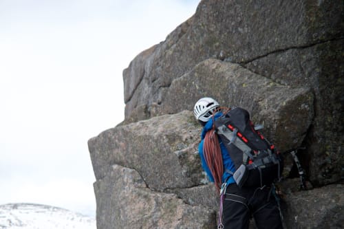 Our instructor gets placing climbing equipment on the edge of an overhang on Fiacaill ridge.