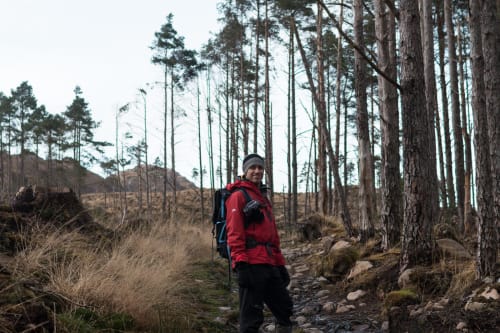 Chris stands facing the camera in a bright red jacket.