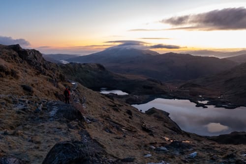 A panorama taken from midway up Snowdon before sunrise. The sky is lightening, but the landscape is still dark.