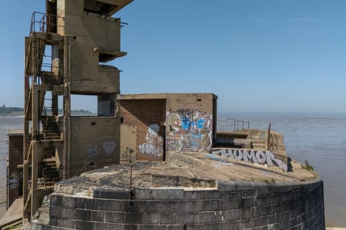 Photo of the roof of part of the battery, showing the concrete tower and stairs and some graffiti on the walls.