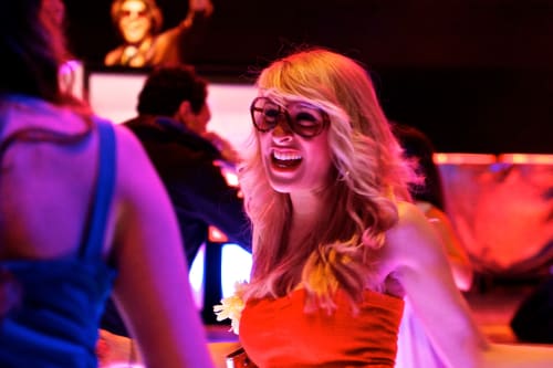 A woman dances whilst looking at her friend.