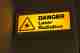 A photo of a lit sign that reads ‘Danger - laser radiation’