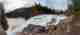 A panorama taken from the top of High Falls. The falls are partially frozen over with white and frothy ice.